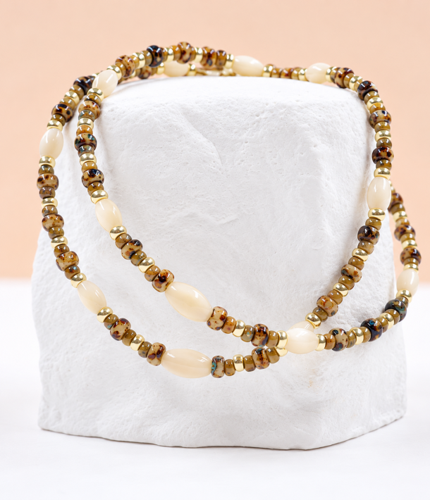 Collier Nikki 31 Bracelet Suzie en perles Miyuki japonaises aux motifs léopard et dorés, avec perles de nacre en forme d'olive, présentés sur un support blanc – Loumaé Bijoux.