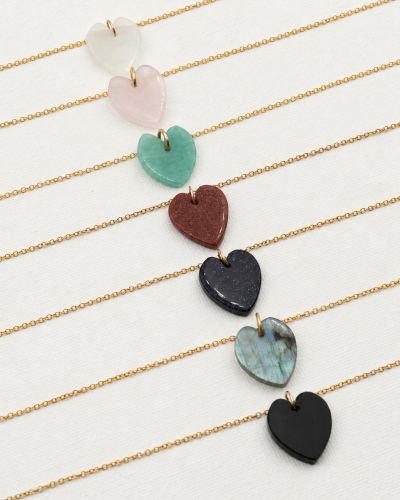 Collier Diva 5 Colliers Gigi Loumaé Bijoux en or laminé, avec pendentifs cœur en pierre de lune, quartz rose, amazonite, gold sandstone, blue sandstone, labradorite et onyx.