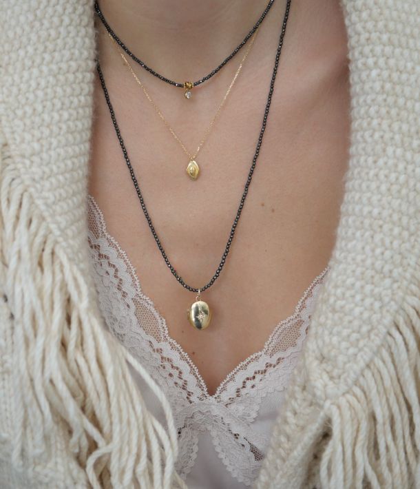 collier en perles grises et pendentif talisman