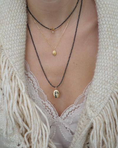 collier en perles grises et pendentif talisman