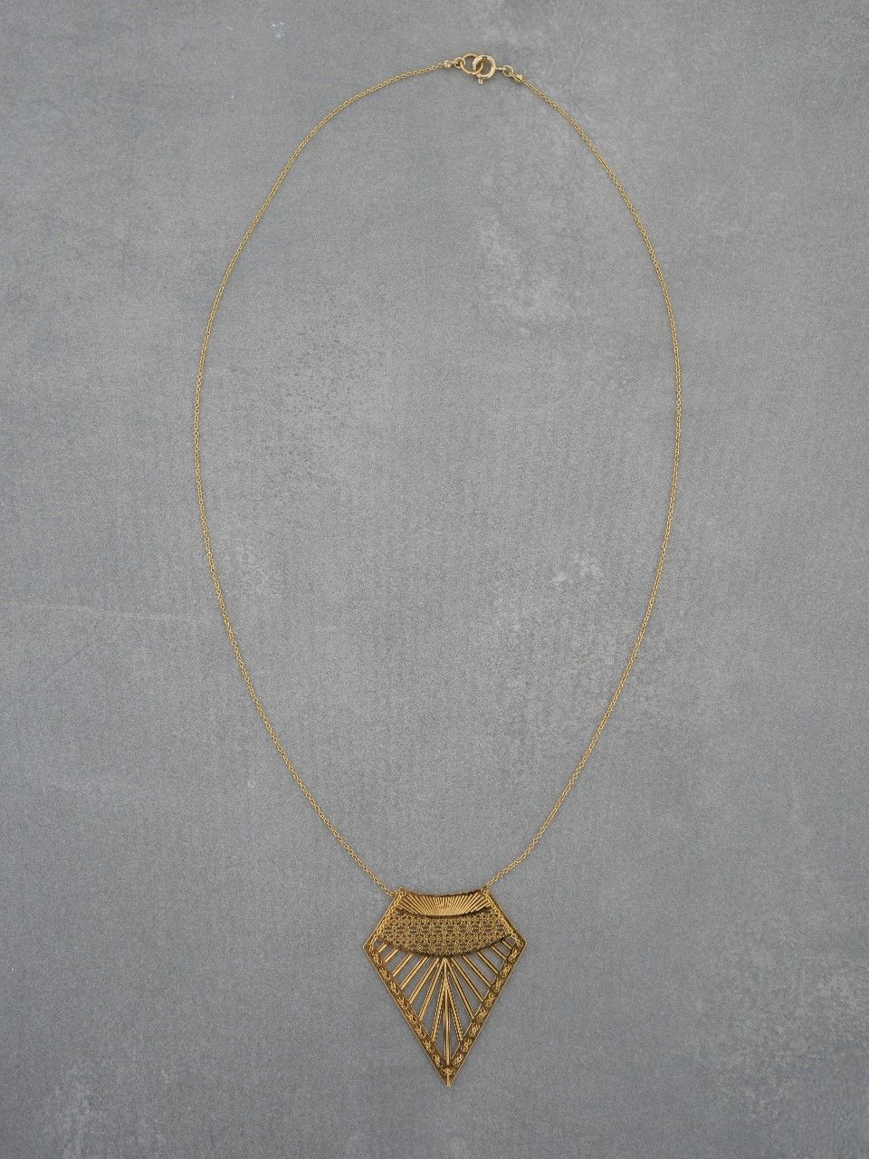 Collier long avec un pendentif en forme de triangle ajouré