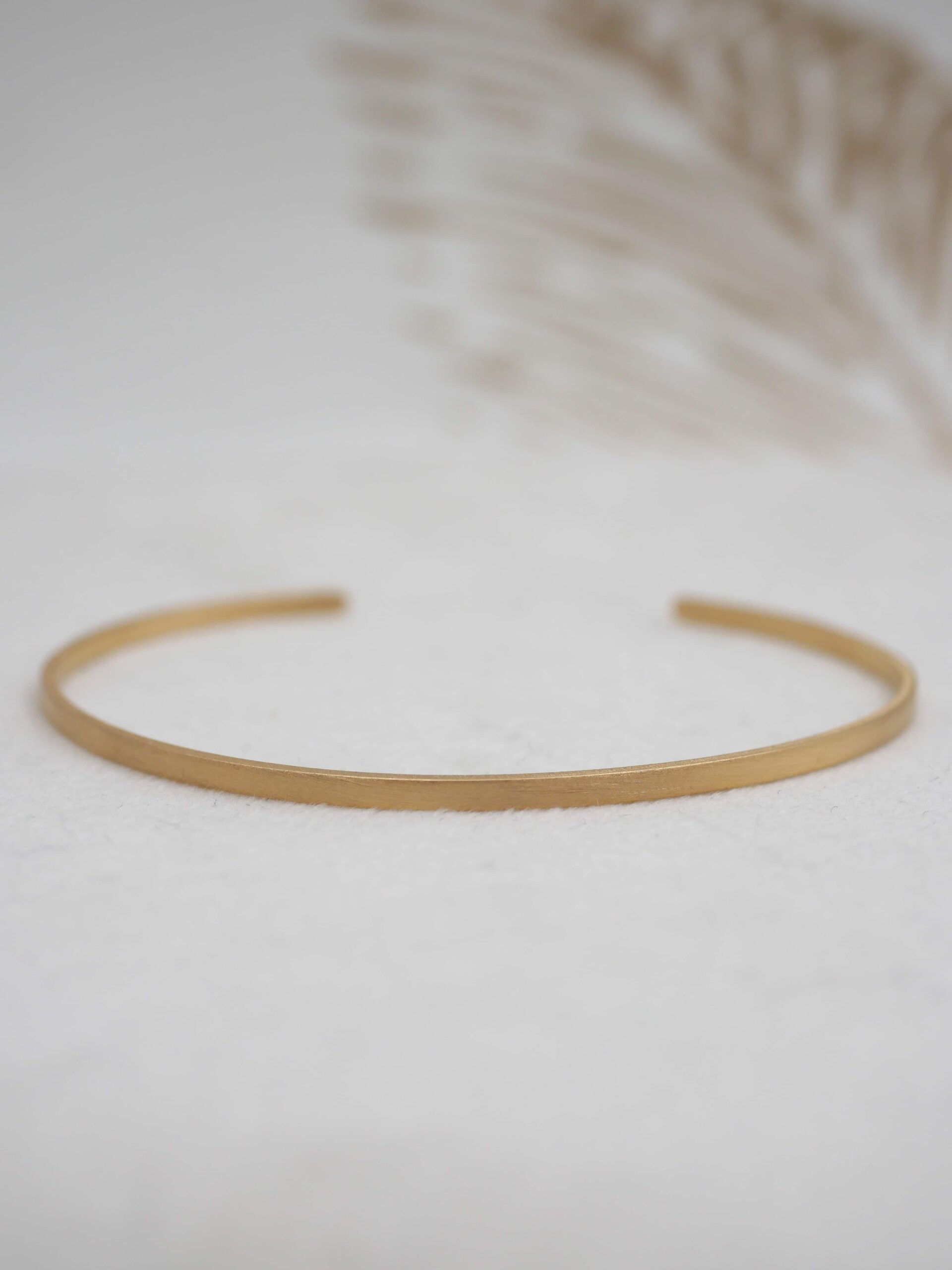 Bracelet jonc Kyoko en laiton plaqué or jaune avec finition brossée mate, ajustable.