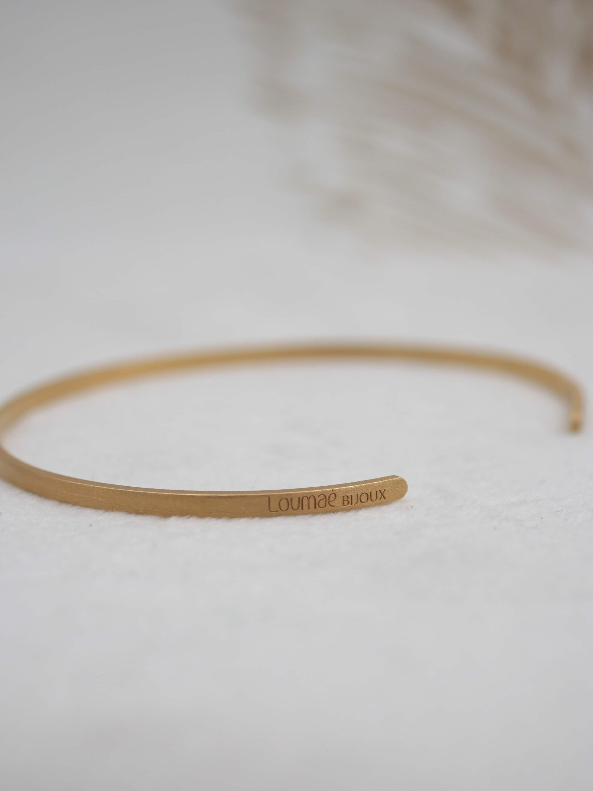 Bracelet jonc Kyoko en laiton plaqué or jaune avec finition brossée mate, ajustable.