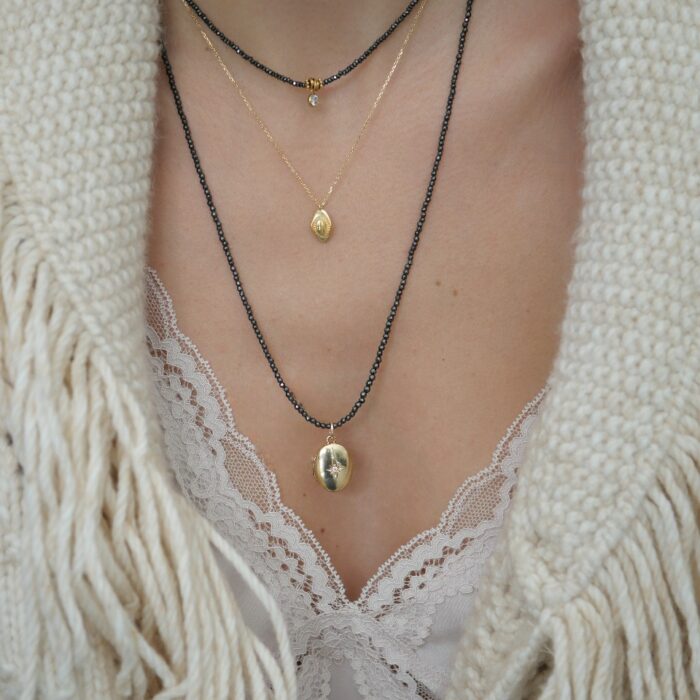 collier en perles grises et pendentif talisman