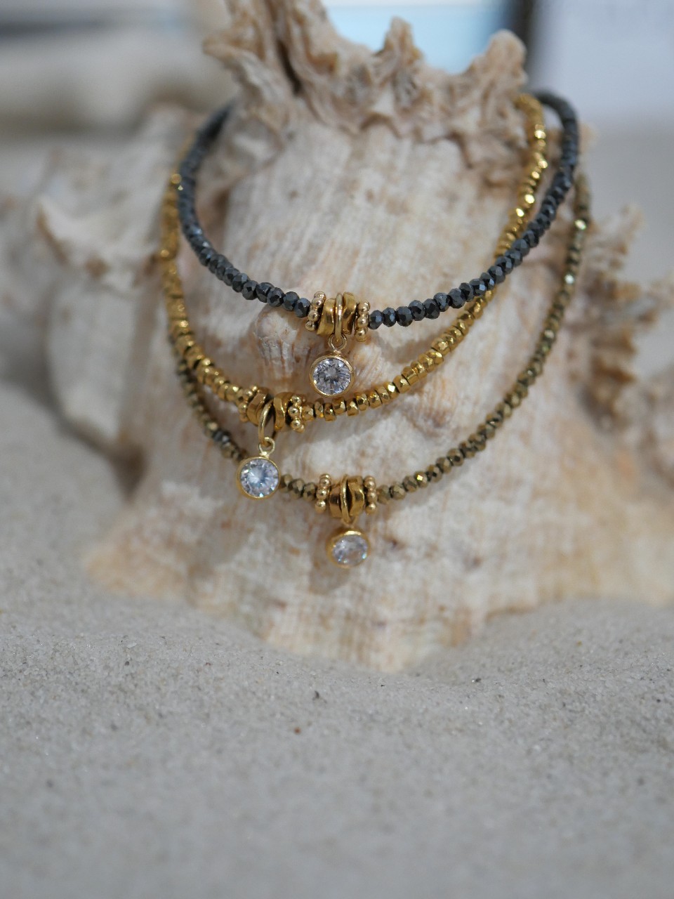 Bracelet Alba 8 Bracelet Alba en hématite dorée et or laminé (gold filled) porté au poignet, composé de fines perles facettées aux reflets lumineux et d’un délicat pendentif serti d’un zirconium. Bijou fin, élégant et intemporel pour femme.