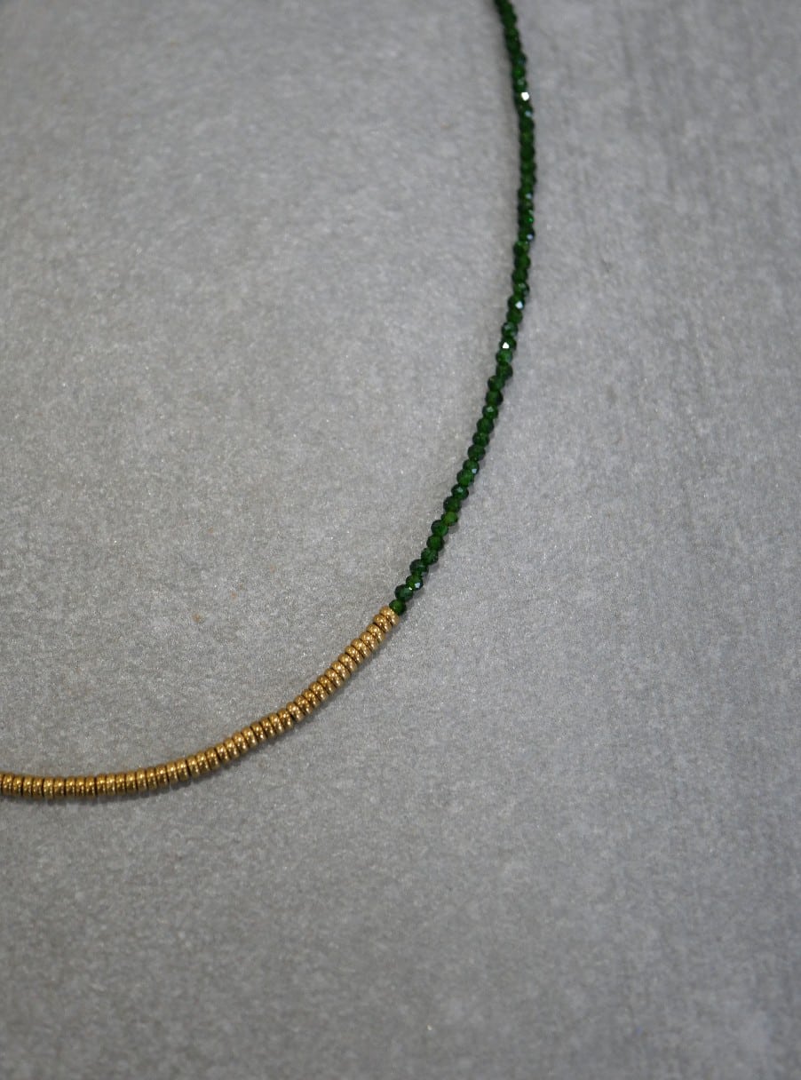 Collier Stella green 3 Collier Stella en Green Sandstone verte facettée et hématite dorée porté sur une chemise blanche, bijou fin et lumineux fabriqué à la main.
