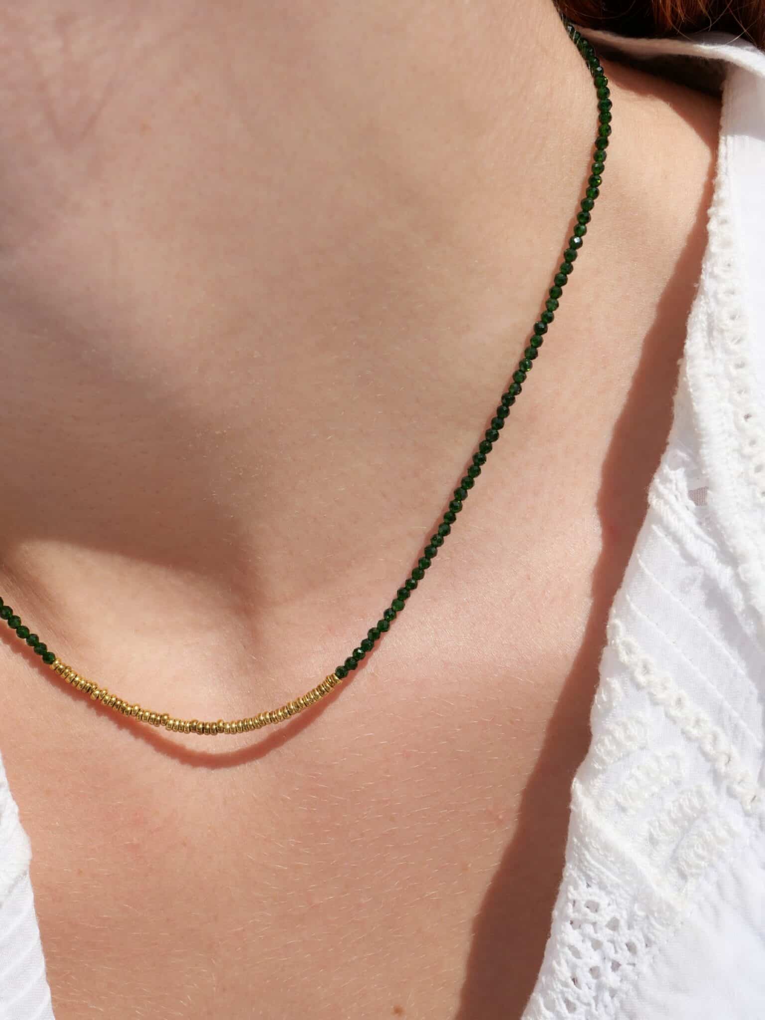 Collier Stella green 1 Collier Stella en Green Sandstone verte facettée et hématite dorée porté sur une chemise blanche, bijou fin et lumineux fabriqué à la main.