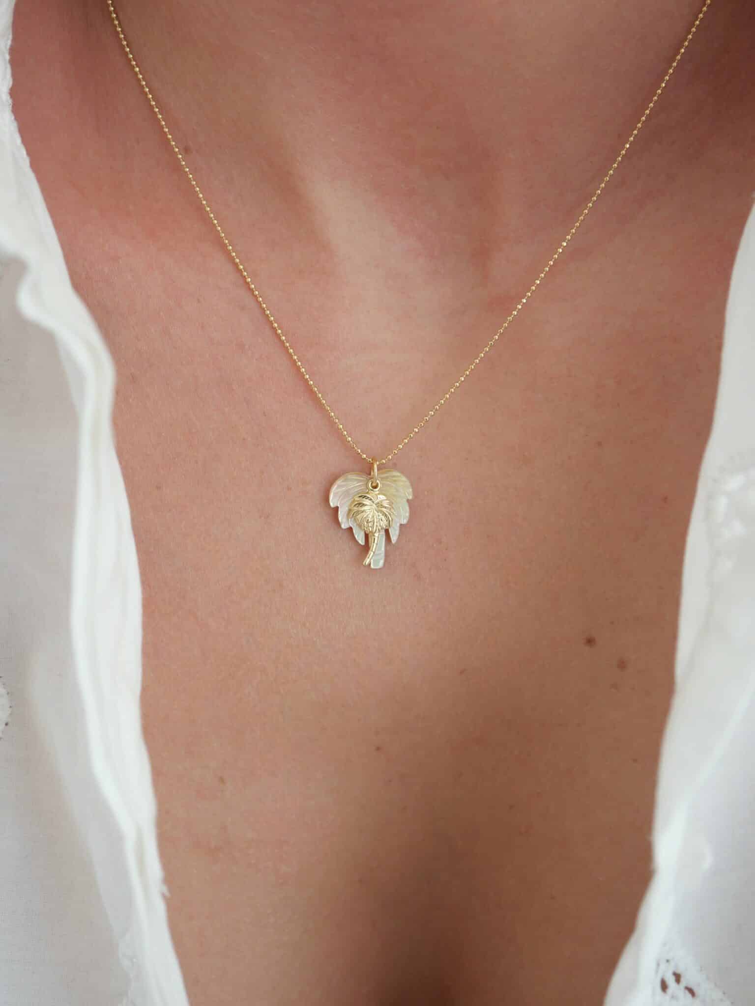 Collier Pita 1 Collier Pita avec chaîne plaquée or et double pendentif palmier en nacre naturelle et or laminé, bijou femme esprit bohème chic.