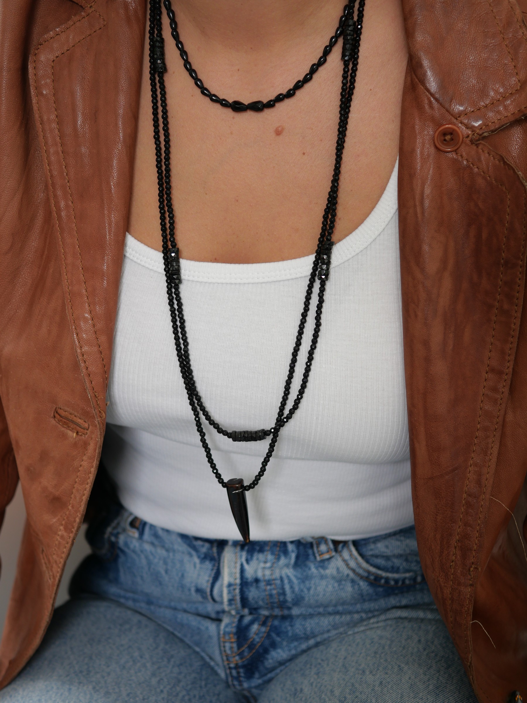 Collier Sweet rebel 3 Collier Sweet Rebel en onyx noir associé aux sautoirs Black Betty et Wild Love avec corne en agate, portés sur un débardeur blanc.