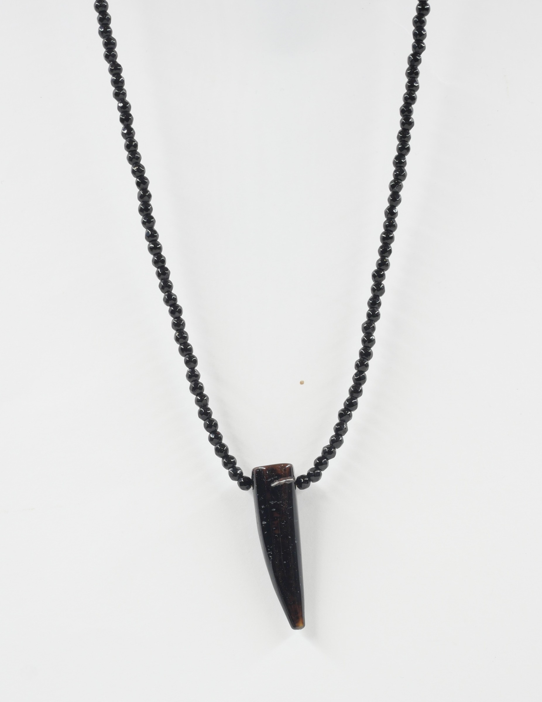 Sautoir Wild love 5 Détail du sautoir Wild Love en perles d’onyx noir avec pendentif corne en agate aux nuances brunes, sur fond blanc.