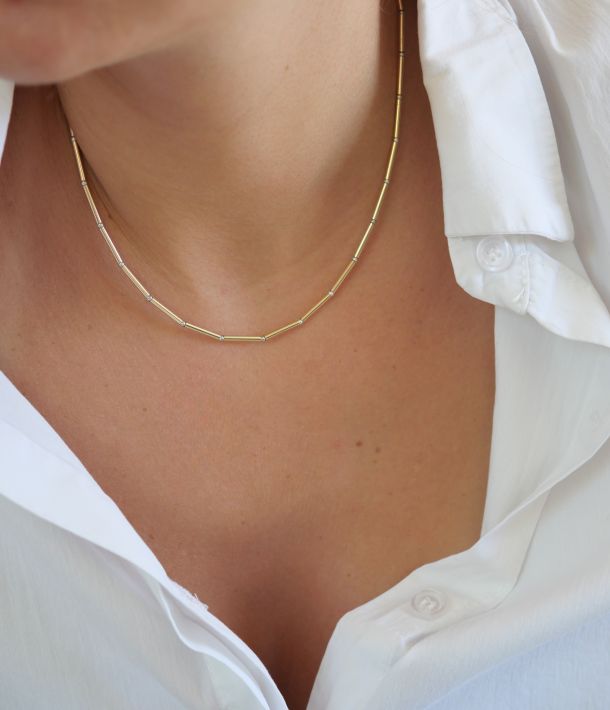 Collier Nova en tubes d’or laminé et perles en argent 925 porté avec une chemise blanche