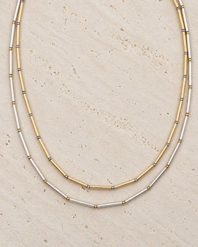 Collier Nova Loumaé Bijoux en deux versions bicolores, tubes en or laminé et argent 925, sur travertin clair.