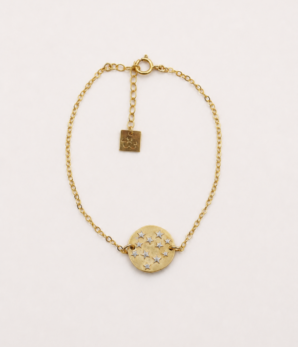Collier Alba 14 Bracelet Céleste en gold filled avec médaille dorée et étoiles en argent rhodié blanc, présenté à plat sur fond crème.