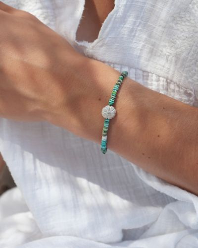 Bracelet Naya en turquoise naturelle composé de fines perles et d'un pendentif oursin en argent 925, bijou artisanal aux inspirations marines.