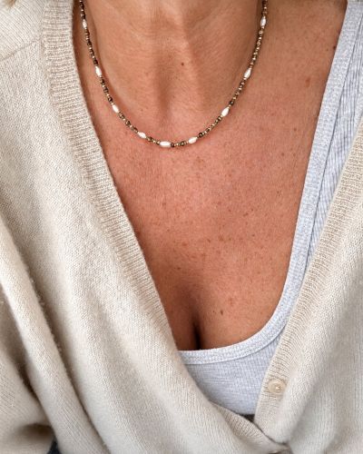Collier Suzie en perles Miyuki léopard et dorées, avec perles de nacre, porté sur la peau avec un gilet écru – Loumaé Bijoux.