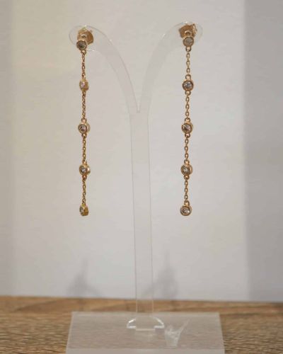 Boucles d'oreilles Leslie en plaqué or 3 microns avec chaîne fine et zircons sertis, pendantes élégantes et lumineuses.
