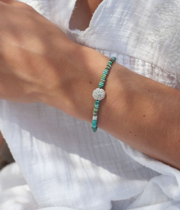Bracelet Naya en turquoise naturelle composé de fines perles et d'un pendentif oursin en argent 925, bijou artisanal aux inspirations marines.