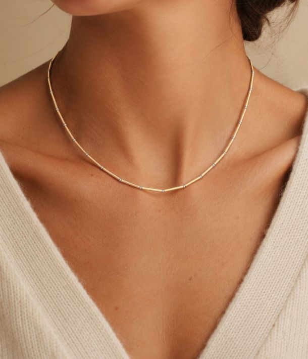 Collier Alba 13 Collier Nova en tubes d’or laminé et perles en argent 925 porté avec un pull crème.