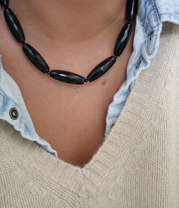 Collier Sweet rebel 9 Collier Big Mama en pierres d’onyx noir facettées, porté au cou avec une chemise en jean et un pull crème — Loumaé Bijoux.